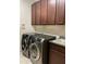 This laundry room offers a front load washer and dryer and built-in cabinets at 11648 Palmetto Pine St, Riverview, FL 33569