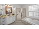 Bathroom showcasing a glass shower, soaking tub, and granite countertop vanity at 11815 Marblehead Dr, Tampa, FL 33626