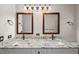 Bathroom with double sinks, granite countertops, wood-framed mirrors, and updated fixtures at 11815 Marblehead Dr, Tampa, FL 33626