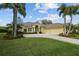 Inviting exterior of a yellow home featuring a wide driveway, a two-car garage, and professionally landscaped front yard at 11815 Marblehead Dr, Tampa, FL 33626