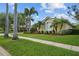 Lush landscaping frames this house with a well-manicured lawn and sidewalk leading to a beautiful Florida home at 11815 Marblehead Dr, Tampa, FL 33626
