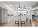 The all-white kitchen features a center island with bar stool seating and elegant lighting at 11815 Marblehead Dr, Tampa, FL 33626