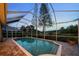 Screened-in pool area with brick flooring offers a private outdoor retreat surrounded by lush greenery and a tranquil setting at 11815 Marblehead Dr, Tampa, FL 33626