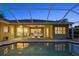 Inviting pool area with a screened-in enclosure, brick patio, and lush green landscape, perfect for outdoor entertaining at 11815 Marblehead Dr, Tampa, FL 33626