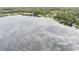 Scenic aerial view of a tranquil lake, showcasing lush shoreline vegetation and the reflection of the sky above at 12651 Tinley Rd, New Port Richey, FL 34654