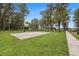 Community amenities include a basketball court and playground surrounded by lush greenery and mature trees at 12651 Tinley Rd, New Port Richey, FL 34654