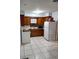 Cozy kitchen features a vintage-style stove and refrigerator, complementing knotty wood cabinets and light tile floors at 12651 Tinley Rd, New Port Richey, FL 34654