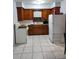 Cozy kitchen features a vintage-style stove and refrigerator, complementing knotty wood cabinets and light tile floors at 12651 Tinley Rd, New Port Richey, FL 34654