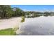 Scenic lake view featuring a sandy beach, lush trees, and calm waters under a partly cloudy sky at 12651 Tinley Rd, New Port Richey, FL 34654