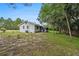 Quaint home featuring a screened porch, grassy yard, and surrounded by mature trees, set on a spacious lot at 12651 Tinley Rd, New Port Richey, FL 34654