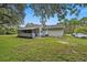 Quaint home featuring a screened porch, grassy yard, and convenient parking, all set on a spacious lot at 12651 Tinley Rd, New Port Richey, FL 34654