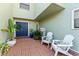 Inviting front porch featuring brick pavers, seating, potted plants, and a blue front door at 1306 W Charter St, Tampa, FL 33602