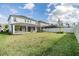 Expansive backyard with a lush lawn, screened-in porch, and white privacy fence perfect for outdoor activities at 13676 Stansil Ave, Odessa, FL 33556