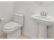 Half bathroom features pedestal sink, tiled floors, and a modern toilet at 13676 Stansil Ave, Odessa, FL 33556