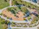 An aerial view of a playground with slide, a see-saw, and walking path surrounded by new homes at 13676 Stansil Ave, Odessa, FL 33556