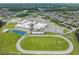 The aerial view shows the school complex with a sports field and basketball court in a residential area with water features at 13676 Stansil Ave, Odessa, FL 33556