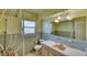 Vintage-style bathroom with unique pink fixtures, tiled walls, and a large mirror at 1450 Highfield Dr, Clearwater, FL 33764