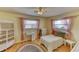 Cozy bedroom features two windows with pink curtains and light, neutral walls at 1450 Highfield Dr, Clearwater, FL 33764