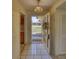 Inviting foyer with white tile flooring, decorative front door and view into a spacious living area at 1450 Highfield Dr, Clearwater, FL 33764