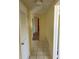 Hallway with tile flooring, white doors, and a glimpse into a room with wood flooring at 1450 Highfield Dr, Clearwater, FL 33764