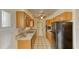 Functional kitchen with wood cabinetry, tile countertops, black appliances, and ample storage space at 1450 Highfield Dr, Clearwater, FL 33764