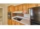 Compact kitchen area with tiled counters, wood cabinets, modern appliances and decorative backsplash at 1450 Highfield Dr, Clearwater, FL 33764