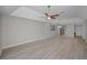 Bright living room with modern ceiling fan, tray ceiling, and wood-look floors at 147 Bluff View Dr # 304, Belleair Bluffs, FL 33770