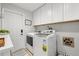 Bright laundry room with modern washer and dryer, white cabinetry and door to the exterior at 1472 47Th Ne Ave, St Petersburg, FL 33703