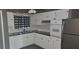 Charming kitchen featuring white cabinetry, modern appliances, and a stylish black and white window treatment at 1507 N Lake Dr, Sun City Center, FL 33573