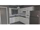 Charming kitchen featuring white cabinetry, modern appliances, and a stylish black and white window treatment at 1507 N Lake Dr, Sun City Center, FL 33573