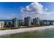 Stunning aerial view of beachfront condos, a white sandy beach, and sparkling ocean waters on a sunny day at 1520 Gulf Blvd # 805, Clearwater Beach, FL 33767