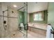 Bathroom featuring a tiled shower, separate bathtub and decorative window at 1520 Gulf Blvd # 805, Clearwater Beach, FL 33767