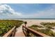 Wooden boardwalk leading to a pristine beach with white sand and clear blue ocean at 1520 Gulf Blvd # 805, Clearwater Beach, FL 33767