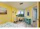 Bright yellow bedroom with colorful decor and a large window with a view of the city and water at 1520 Gulf Blvd # 805, Clearwater Beach, FL 33767