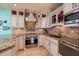 Close-up of kitchen featuring white cabinets, mosaic backsplash, and granite countertops with stainless steel appliances at 1520 Gulf Blvd # 805, Clearwater Beach, FL 33767