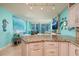 Open concept living room with turquoise walls, modern furniture, and a kitchen with an island and bar stools at 1520 Gulf Blvd # 805, Clearwater Beach, FL 33767