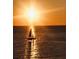 Sailboat gliding on the ocean at sunset with a golden sky and water at 1520 Gulf Blvd # 805, Clearwater Beach, FL 33767