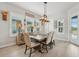 Elegant dining room with a modern chandelier, neutral-toned chairs, and bright natural light at 16371 Frehley Run, Land O Lakes, FL 34638