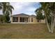 View of home's backyard featuring a screened-in porch, lawn, and tropical landscaping at 1648 Mira Lago Cir, Ruskin, FL 33570