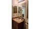Vanity with light wood cabinets, granite counters and double mirrors in bathroom at 1648 Mira Lago Cir, Ruskin, FL 33570