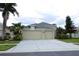 Charming home with a two-car garage, well-maintained lawn, and lush landscaping at 1648 Mira Lago Cir, Ruskin, FL 33570