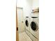 Modern laundry room with stacked washer and dryer set and tile flooring at 1648 Mira Lago Cir, Ruskin, FL 33570