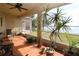 Serene screened patio with tile flooring, ceiling fan, and a view of the calm lake at 1648 Mira Lago Cir, Ruskin, FL 33570