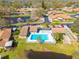 Aerial view of the community with a swimming pool, shuffle board, and pond at 1685 Fry Ct, Dunedin, FL 34698