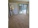 Carpeted bedroom features a sliding glass door to the pool area and view of the kitchen at 1982 Seton Dr, Clearwater, FL 33763