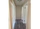 Bright hallway featuring wood-look flooring, linen closet, and neutral paint colors at 1982 Seton Dr, Clearwater, FL 33763