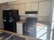 Functional kitchen featuring laminate counters, black appliances, and ample cabinet space at 1982 Seton Dr, Clearwater, FL 33763