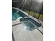 A screened in-ground spa with concrete patio in backyard of home at 1982 Seton Dr, Clearwater, FL 33763
