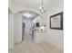 Hallway leads to a kitchen with white cabinets and stainless-steel appliances through an arched doorway at 2807 W Estrella St # 102, Tampa, FL 33629