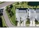Aerial view of townhomes with gray roofs and well-kept lawns bordered by palm trees and a curving street at 284 Hemingway Dr, Oldsmar, FL 34677
